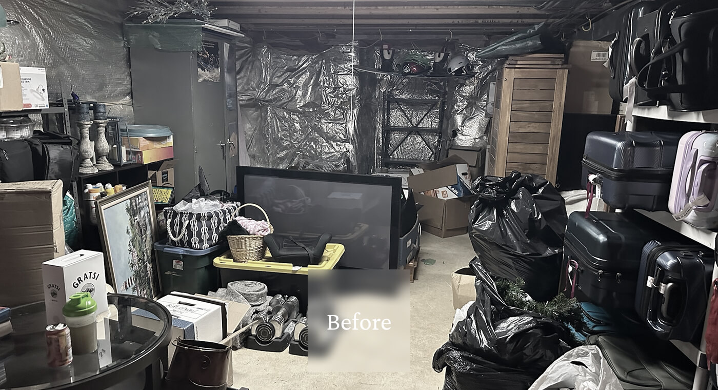 A cluttered storage room filled with boxes, suitcases, black trash bags, and various household items.